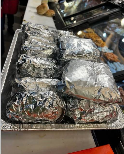 Tray of foil-wrapped sandwiches ready for a catering order at Dyckman Cafe and Grill