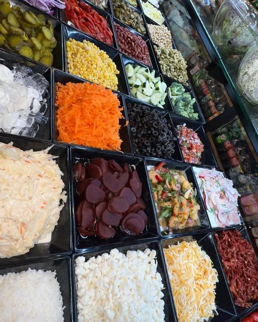 Fresh topping and salad bar with vegetables, cheeses and condiments